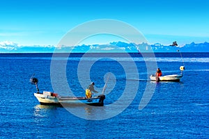 Two fishermen on boats in the Adriatic Sea on a winter evening