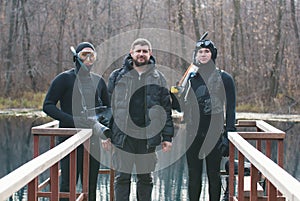Two fishermen in wetsuit and mask and one handsome man in preparation for a hunt.