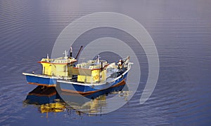 Two fishing boats floating on rippling water