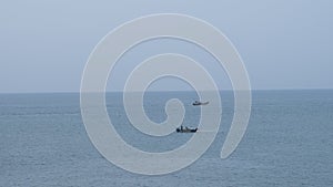 Two fishing boats in the middle of a calm ocean