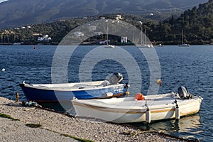 Two fishing boats are moored on the waterfront of the island of Poros Greece on a sunny day