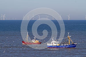 Two fishing boats with seagulls on the north sea