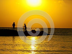 Two fishing friend at sunset sea