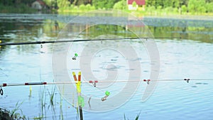 Two fishing rods on the lake in summer day