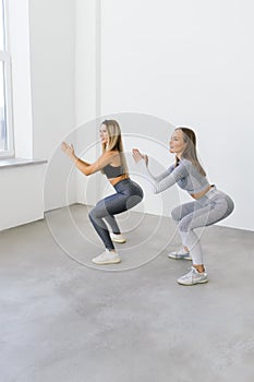 Two fit women doing squats at home, Female workout sport and fitness