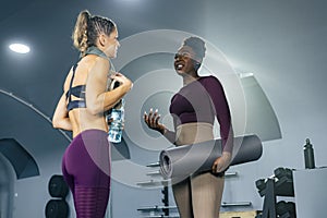 Two fit women in sportswear talking in the gym after workout