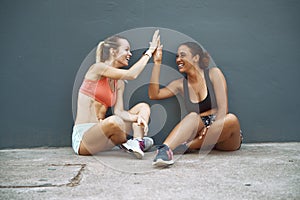 Laughing friends high fiving during a break from their workout photo