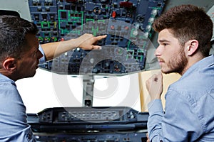 two flight engineers talking in cockpit