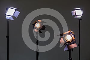 Two floodlights with halogen lamps and Fresnel lens and two led lighting device. Shooting in the interior on a gray background