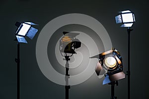 Two floodlights with halogen lamps and Fresnel lens and two led lighting device. Shooting in the interior on a gray background