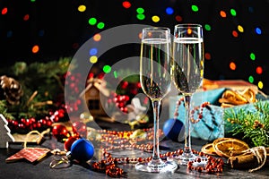 Two flutes with champagne or sparkling wine over holiday or Christmas background.