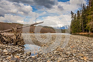 Two fly fishing rods on a dead tree on a river in British Columbia