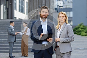 Confident business professionals standing outside office building