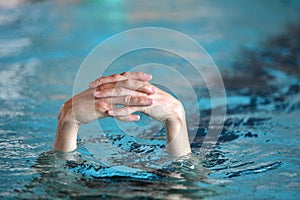 Two folded hands above water