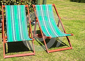 Two folding deck chairs in garden.