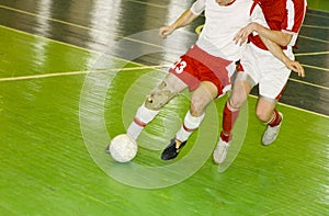 Two football players struggle for ball possession