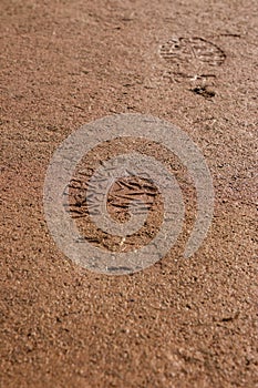 Two Footprints Imprinted Into Damp Sand