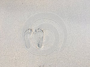 Two Footprints in sand at the Beach