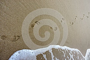 Two footprints on the sea sand, walking on the beach