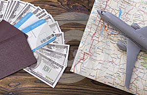 Two foreign passports with enclosed dollar bills with a tourist card and an airplane