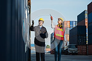 Two foreman man & woman worker working checking at Container cargo harbor to loading containers. Dock male and female staff