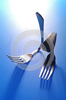 Two forks bent on blue background photo