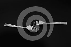 Two forks on the black backround