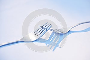 Two forks joined together symbolising togetherness, dependance and unity. This is a symbol of teamwork, relationship and