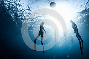 Two free divers ascending from the depth