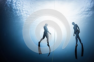 Two free divers ascending from the depth