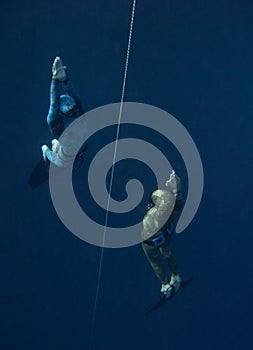 Two freedivers go up from the training depth