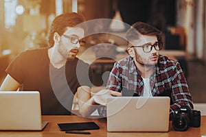 Two Freelance Photographers Work on Laptops