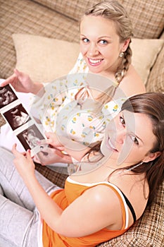 Two freinds are holding a sonogram