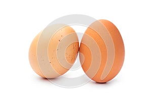 Two fresh brown chicken eggs on a white background