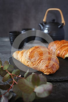 Two fresh croissants and teapot