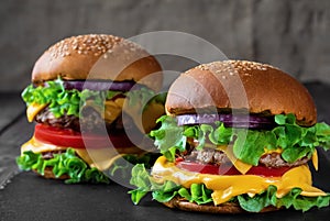 Two fresh hamburger on dark stone table. closeup. Shallow depth of field