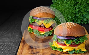 Two fresh hamburger on a wooden table. Closeup. Shallow depth of field