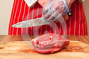 Two fresh high grade rib eye steaks on a wooden cutting board.