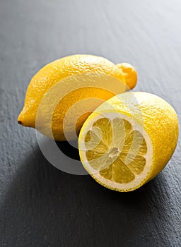 Two fresh lemons on black background