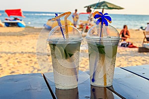 Two fresh mojito cocktails on table on a background of tropical beach