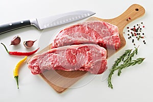 Two fresh raw striploin steak on wooden board