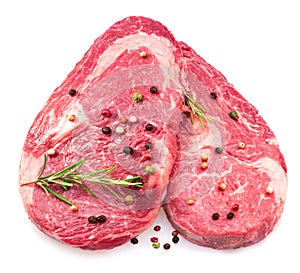 Two fresh ribeye steaks with peppercorn and rosemary isolated on white background. Closeup