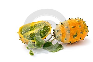 Two fresh ripe kiwano with vine and leaves, Cucumis metuliferus, isolated on white background