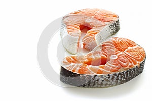 Two fresh salmon steaks with vibrant orange hues and detailed textures, isolated on a white background, perfect for