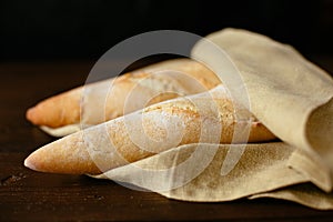 Two freshly baked baguette wrapped in a bakery.