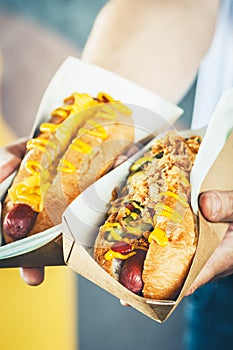 Two freshly prepared hotdogs in a paper box. Food delivery, take away, street food or junk food concept