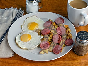 two fried eggs with home fries and kielbasa