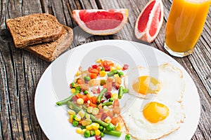 two fried eggs on the plate and vegetables photo