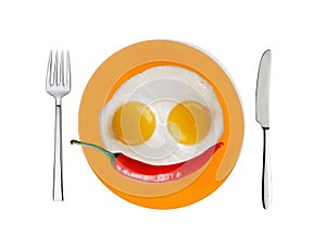 Two fried eggs and red hot chilly pepper on orange plate