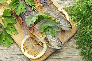 Two fried fish of kind of salmon with aromatic herbs and lemon